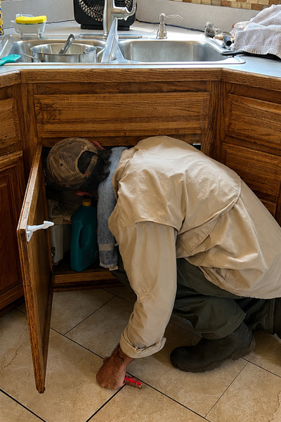 Bug Cops technician applying a preventative pest treatment around the exterior perimeter of a Florida home.