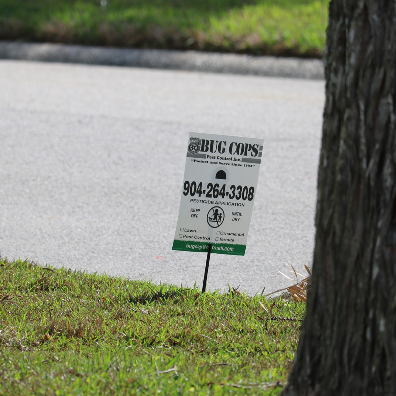 Bug Cops fire ant treatment sign beside a Putnam County property