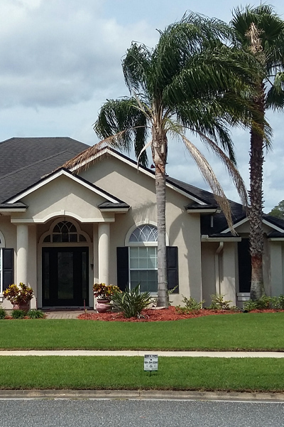Well-maintained Florida home with healthy green lawn, trimmed shrubs, and landscaped planting beds.