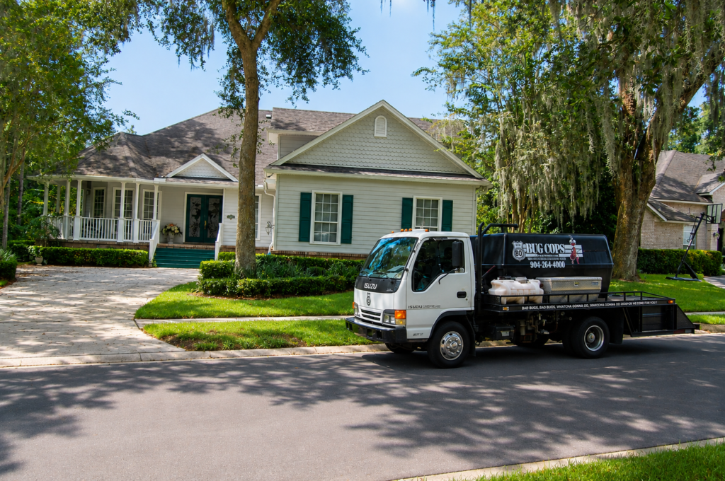 Bug Cops pest control service truck at a residential property representing pest control in Fleming Island FL