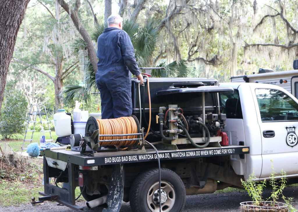 Bug Cops technician preparing termite treatment equipment at a customer property