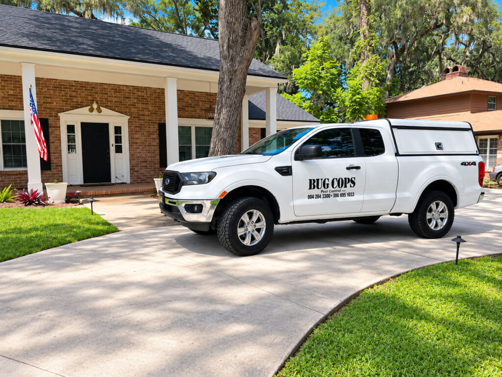 White Bug Cops Pest Control service truck parked outside a residential home in North Florida.