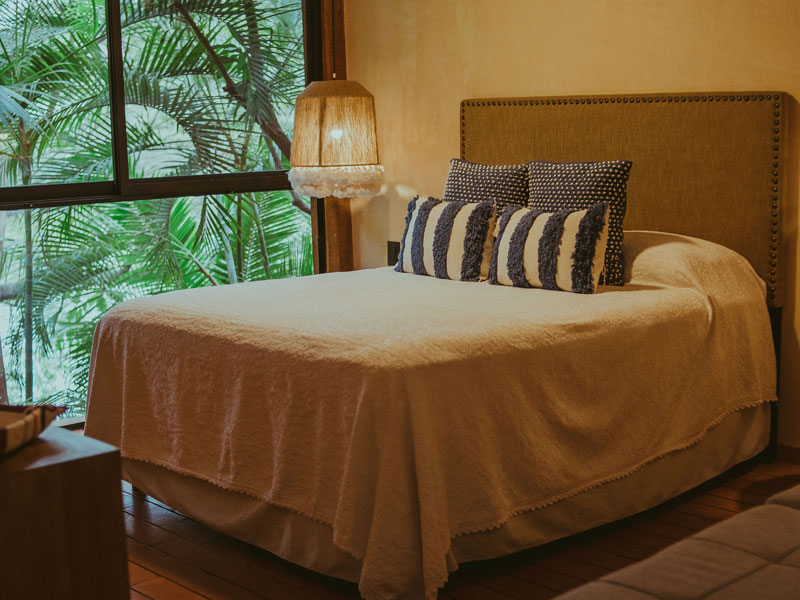 Neatly made bed in a bedroom, showing common areas inspected during bed bug control services.
