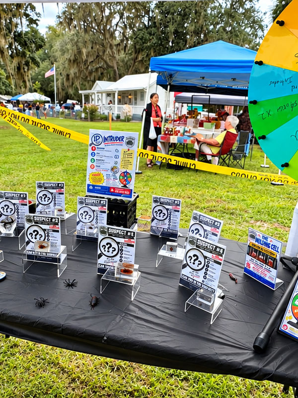 Bug Cops ID the Intruder educational display featuring nine insect and pest specimens, identification clue cards, magnifying glasses, and a colorful prize wheel at the North Florida Fall Festival.